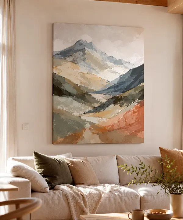 Soft Alpine mountain landscape canvas print above a beige sofa in a warm natural living room interior.